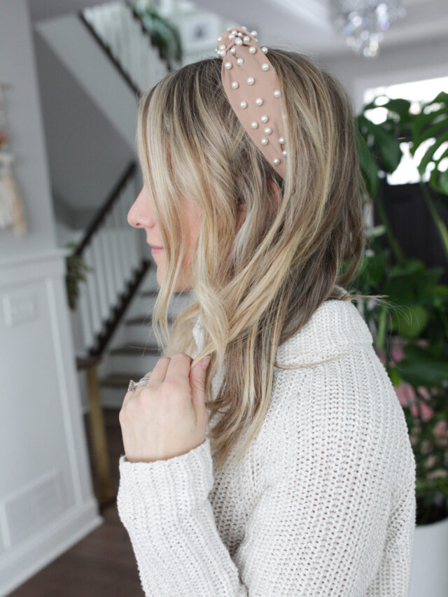 woman in a sweater with a pearl headband in her hair