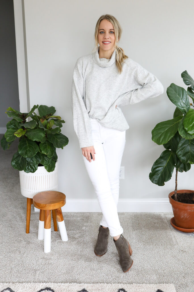 woman wearing grey Sweater. white jeans and Boots