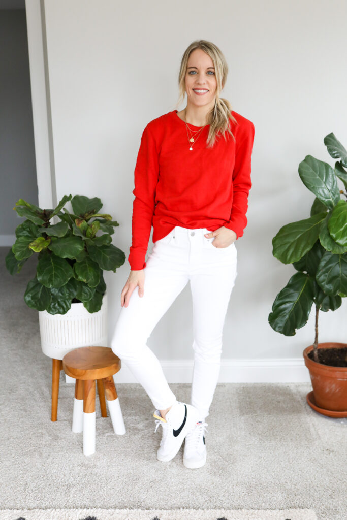 woman wearing white jeans, red Sweatshirt and Sneakers