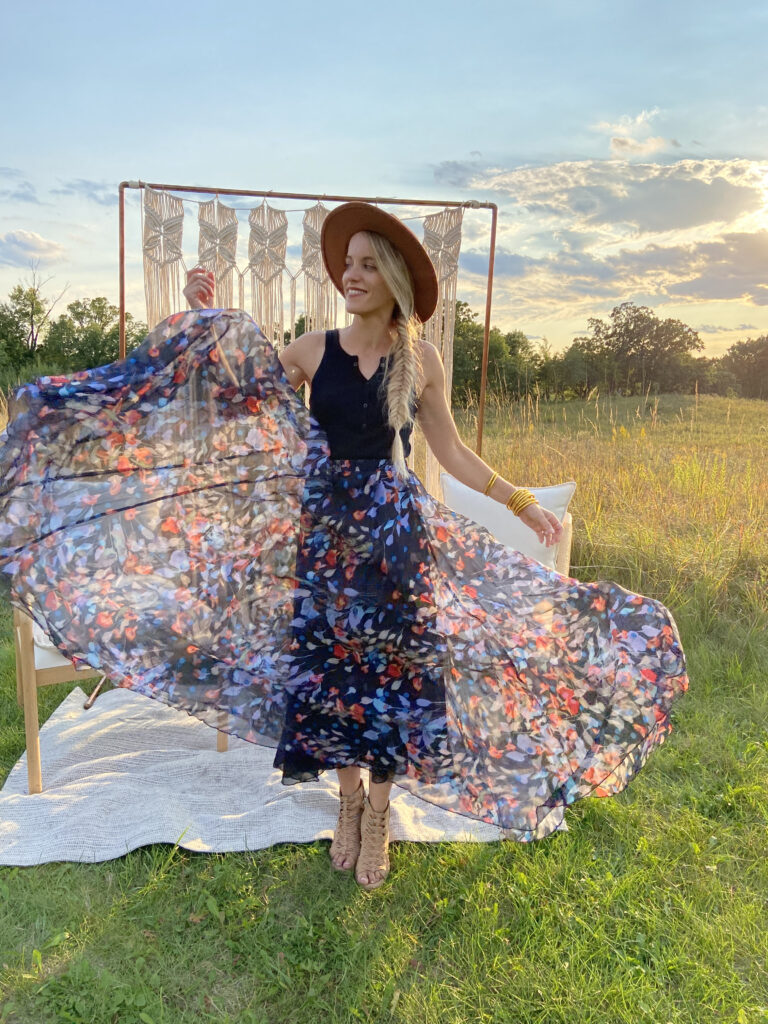 Woman outside in hat, tank top and flowy floral skirt