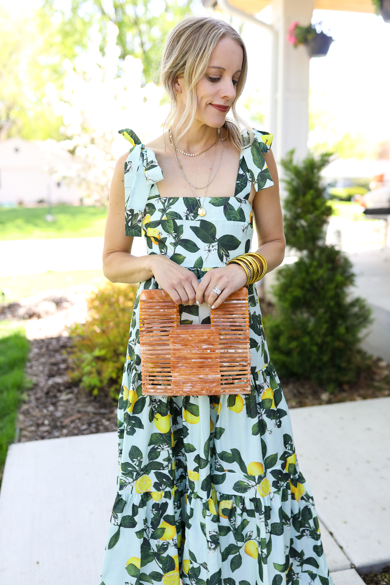 woman in blue and green dress holding bag