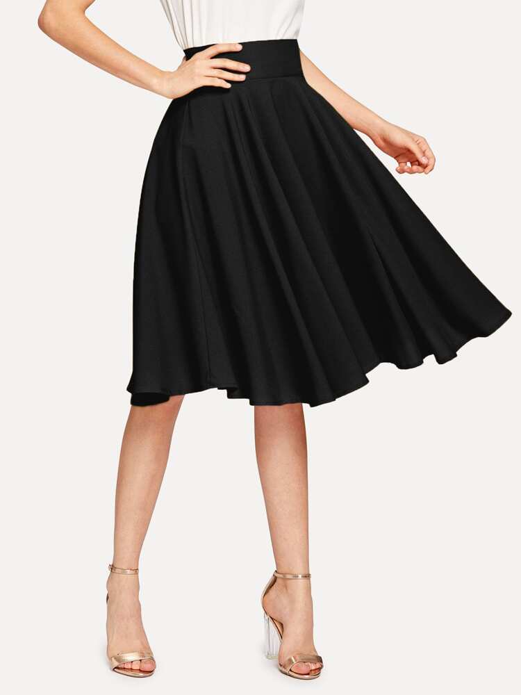 Woman wearing a black circle skirt and gold heels