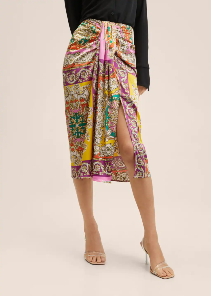 Woman wearing a printed draped skirt and heels