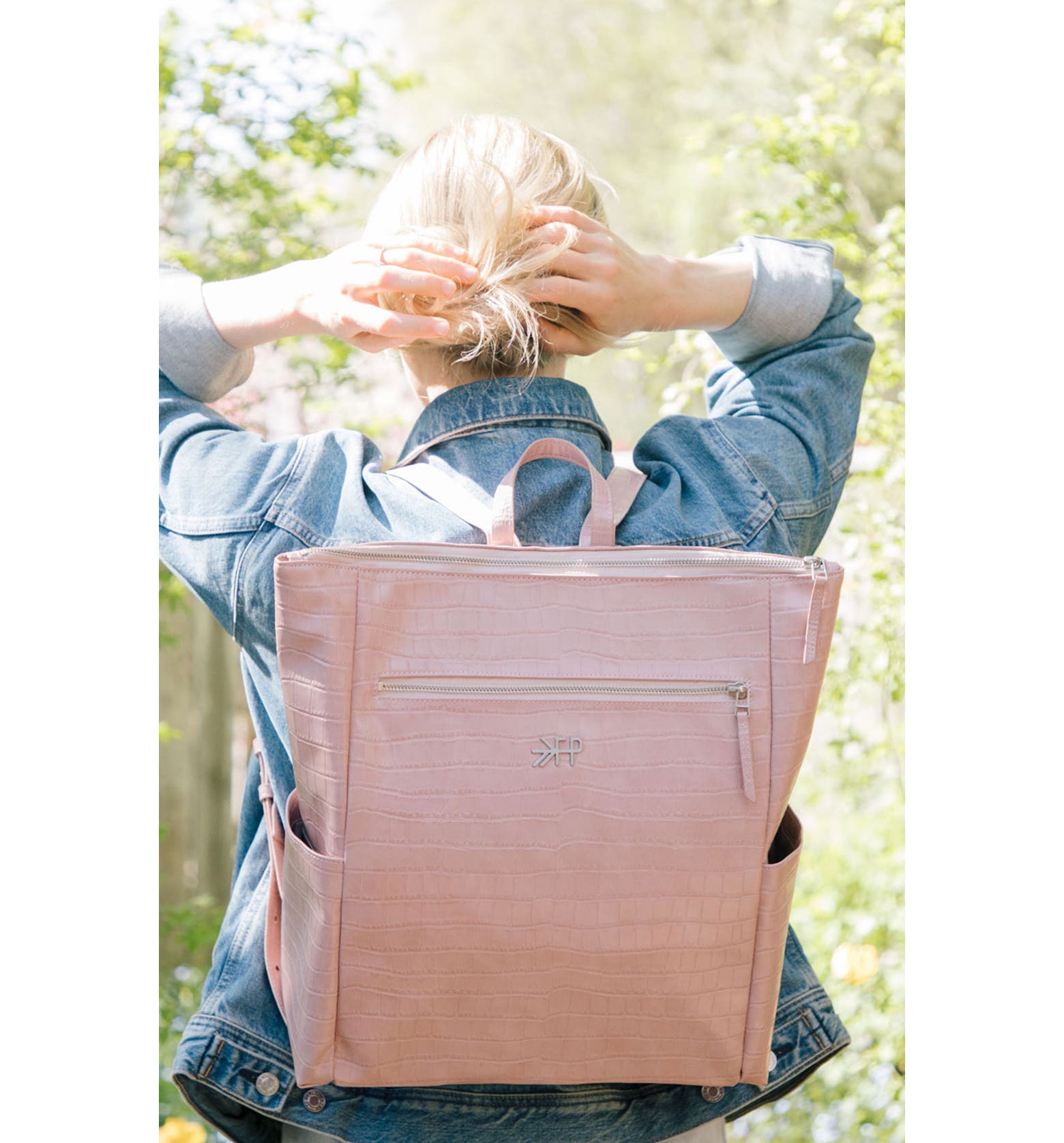 Woman wearing pink Freshly Picked Faux Leather Diaper Backpack