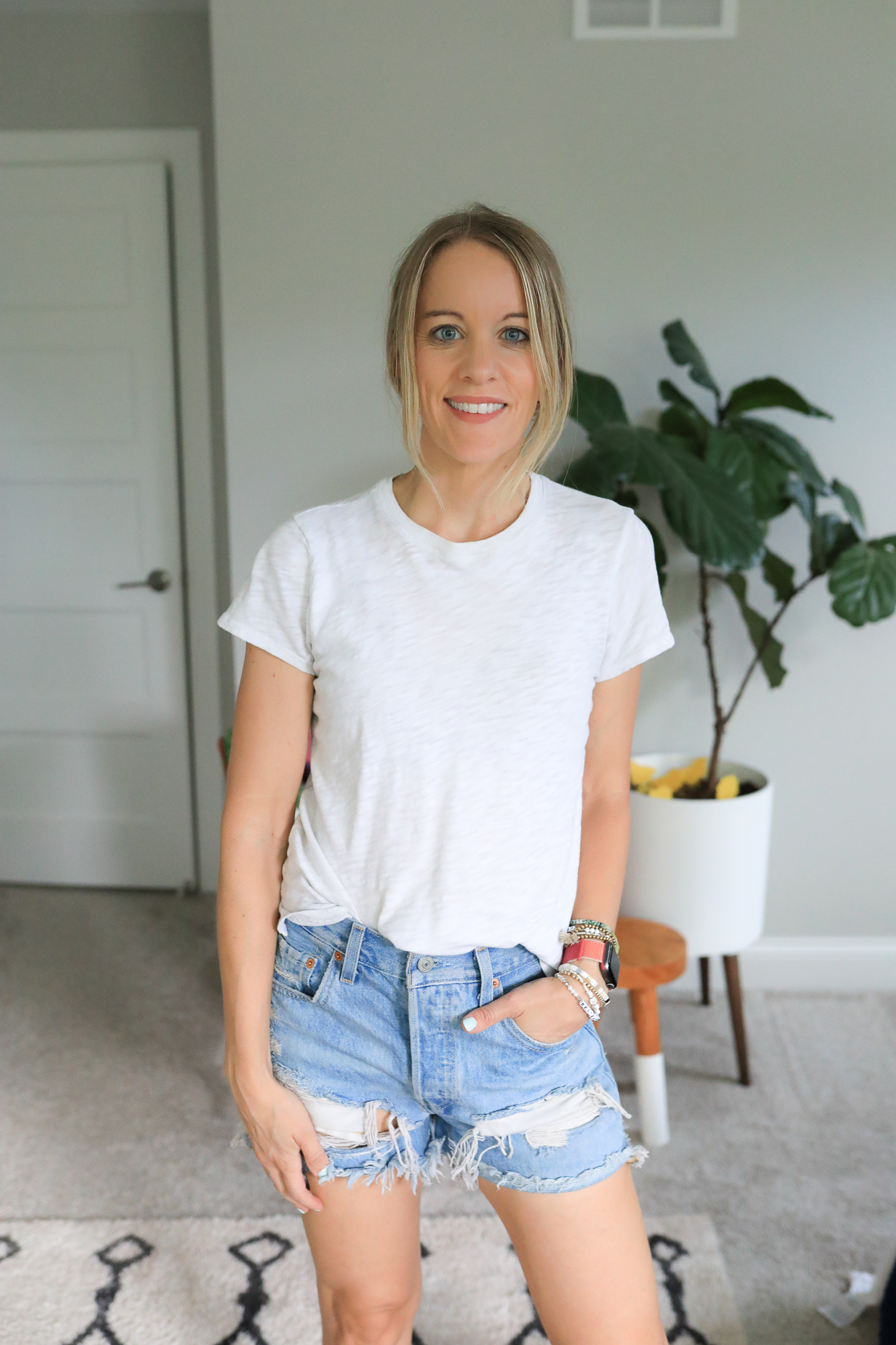 woman wearing jean shorts and white tee
