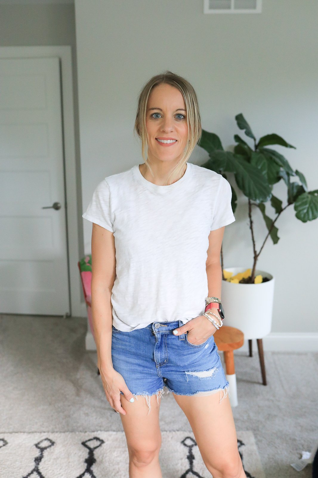 woman wearing jean shorts and white tee