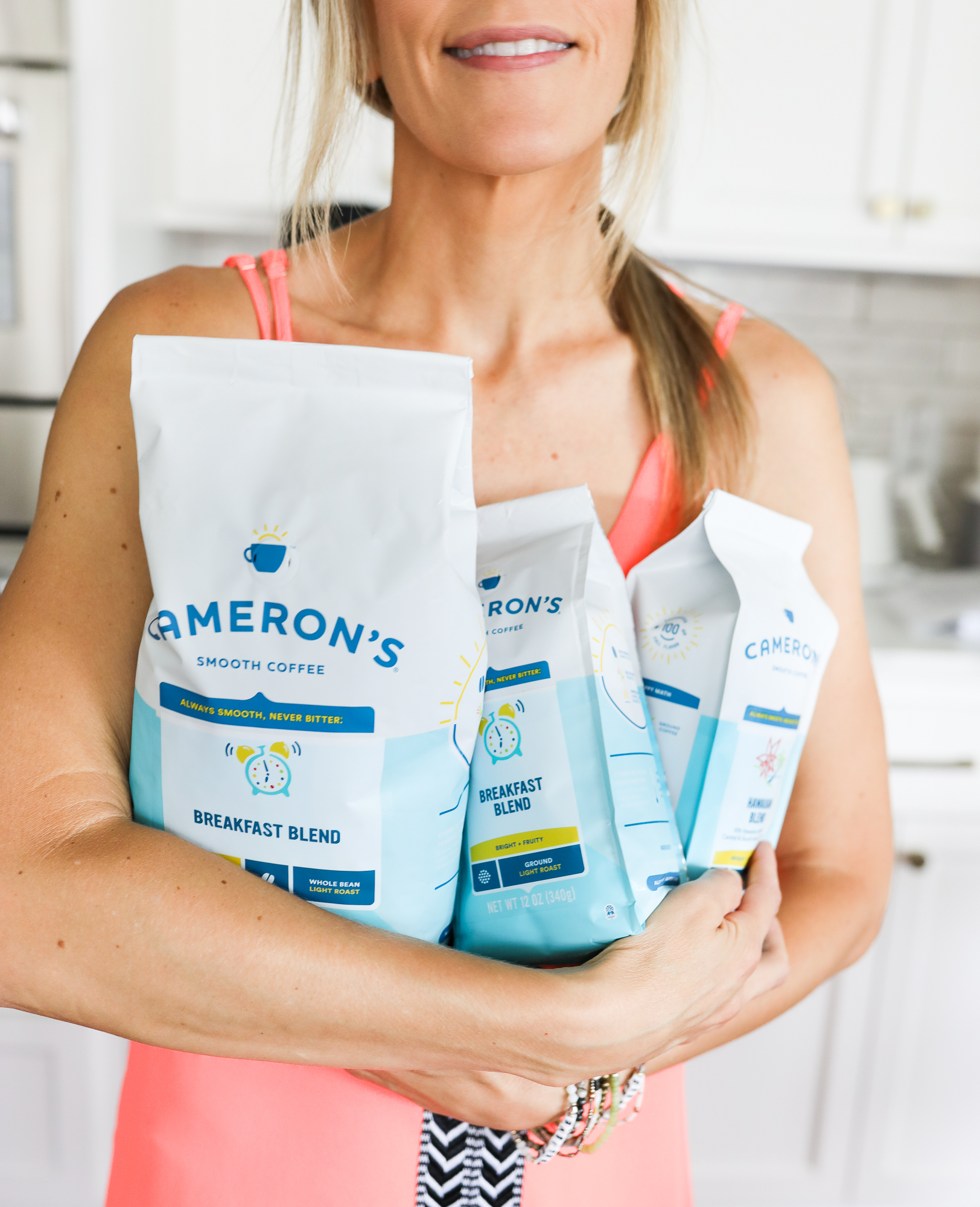 woman holding 3 bags of cameron's coffee