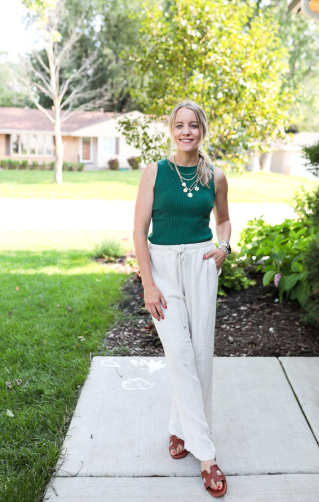 Woman wearing linen pants, green tank and sandals.