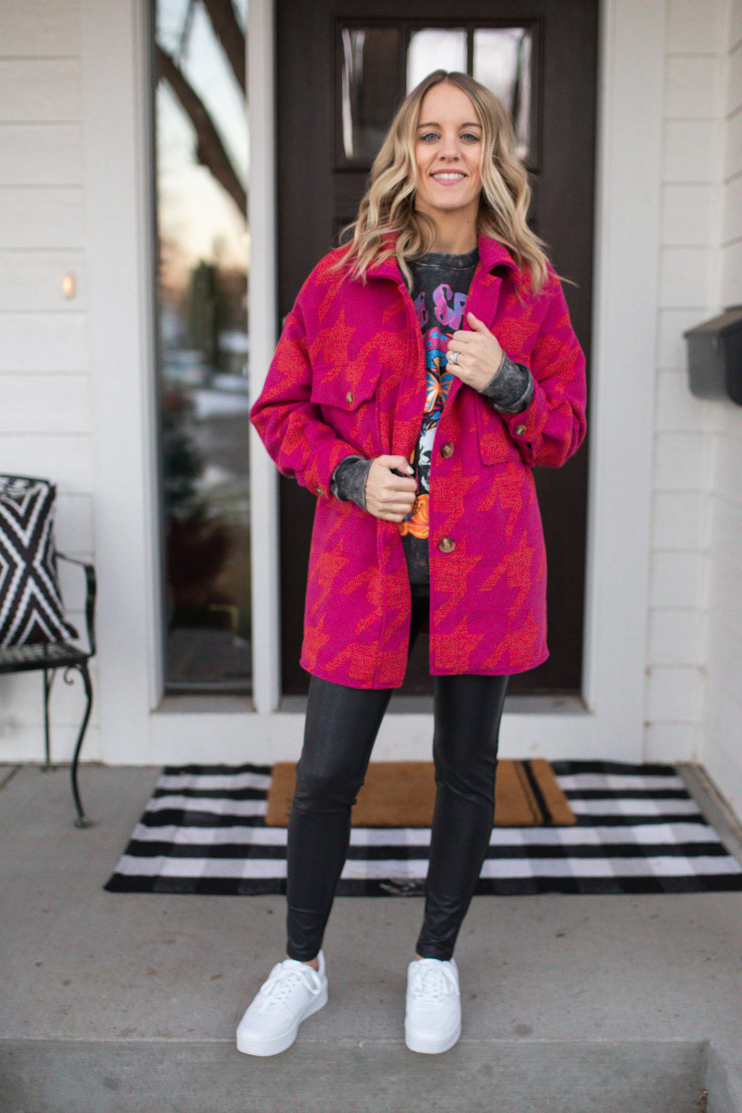 woman wearing faux leather leggings, pink jacket and graphic tee sweatshirt