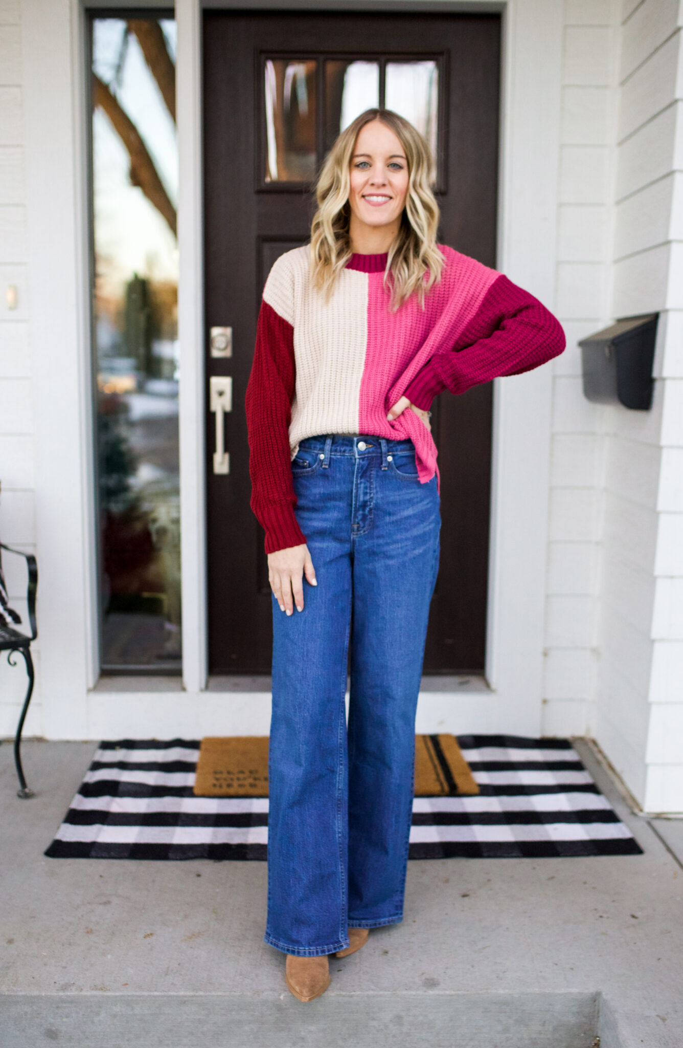 flare jeans, pink colorblock sweater and boots