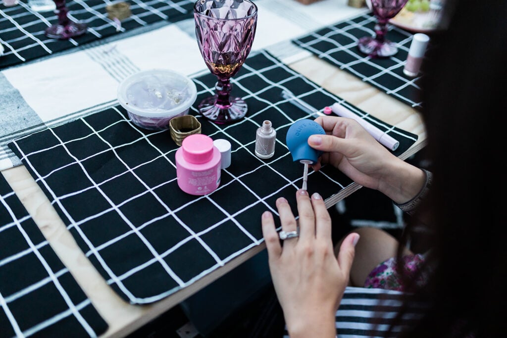 woman painting her nails with olive and june