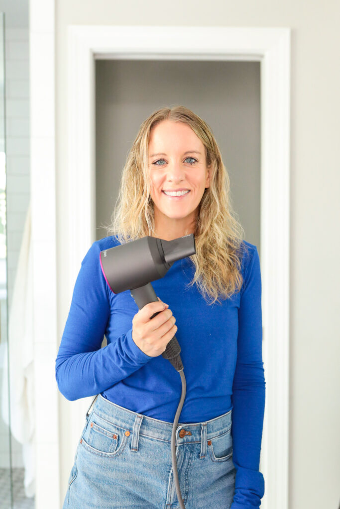 woman holding a dyson hair dryer