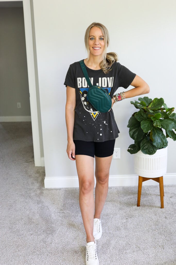 woman wearing bike shorts, graphic tee and crossbody bag