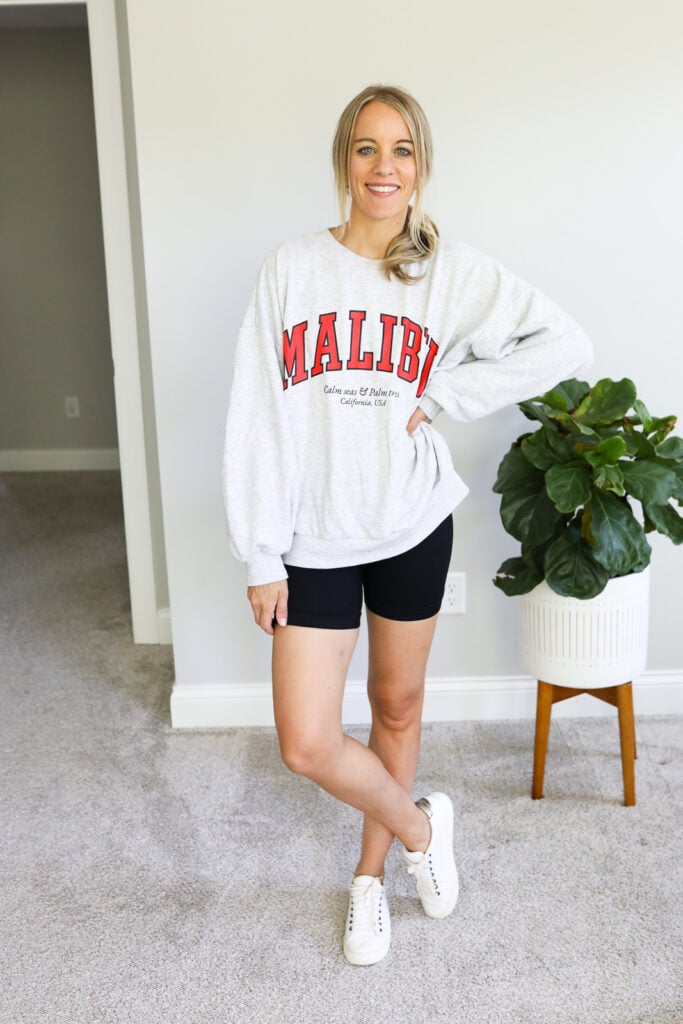 woman wearing bike shorts and oversized graphic sweatshirt