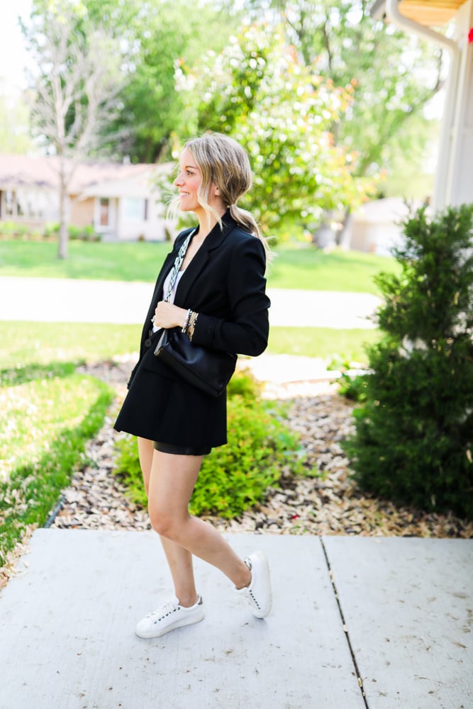 woman wearing faux leather shorts and sneakers and blazer