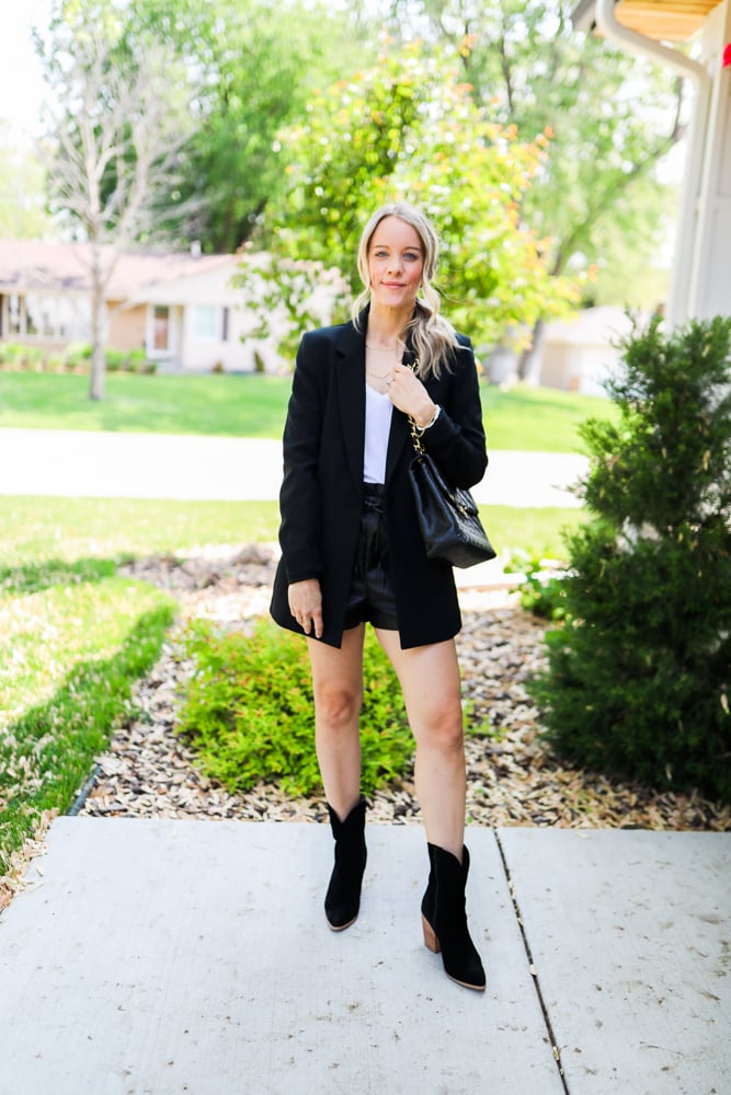 woman wearing faux leather shorts, blazer and cowboy boots