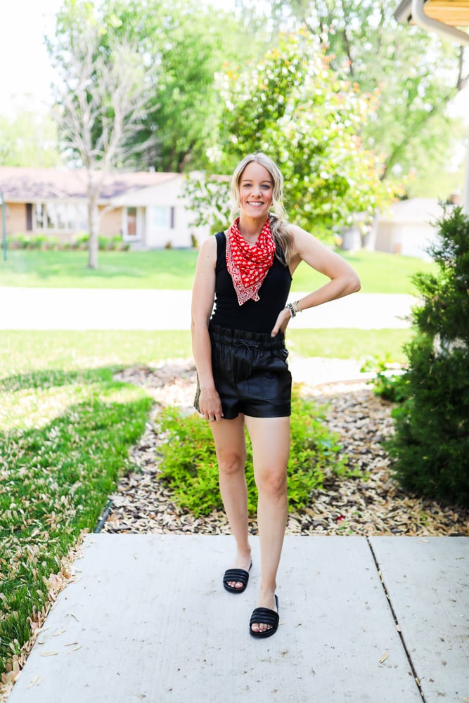 woman wearing faux leather shorts black bodysuit and bandana