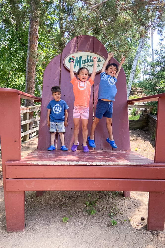 3 kids on giant chair at Madden's on Gull Lake