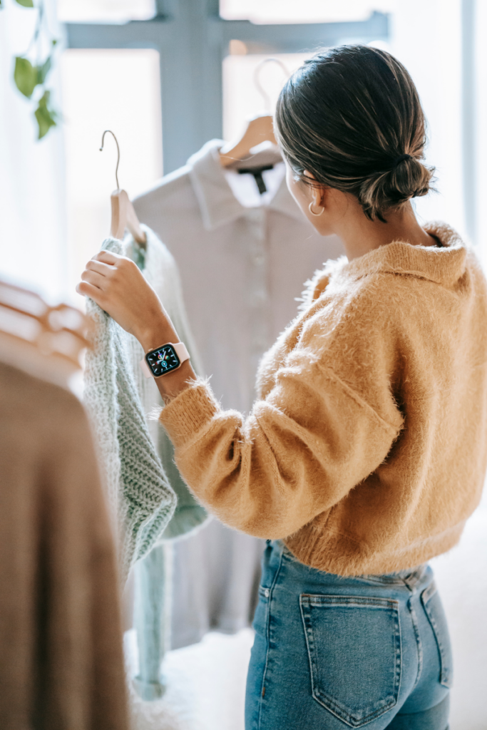 Woman looking at clothes on hangers