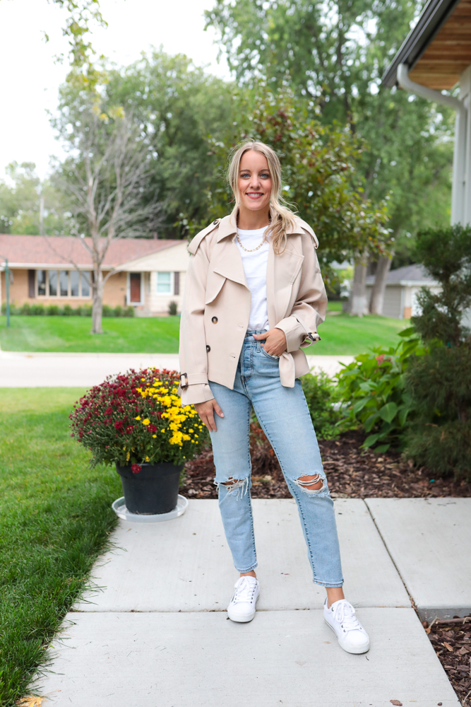 woman in distressed jeans, white tee and cropped trench coat