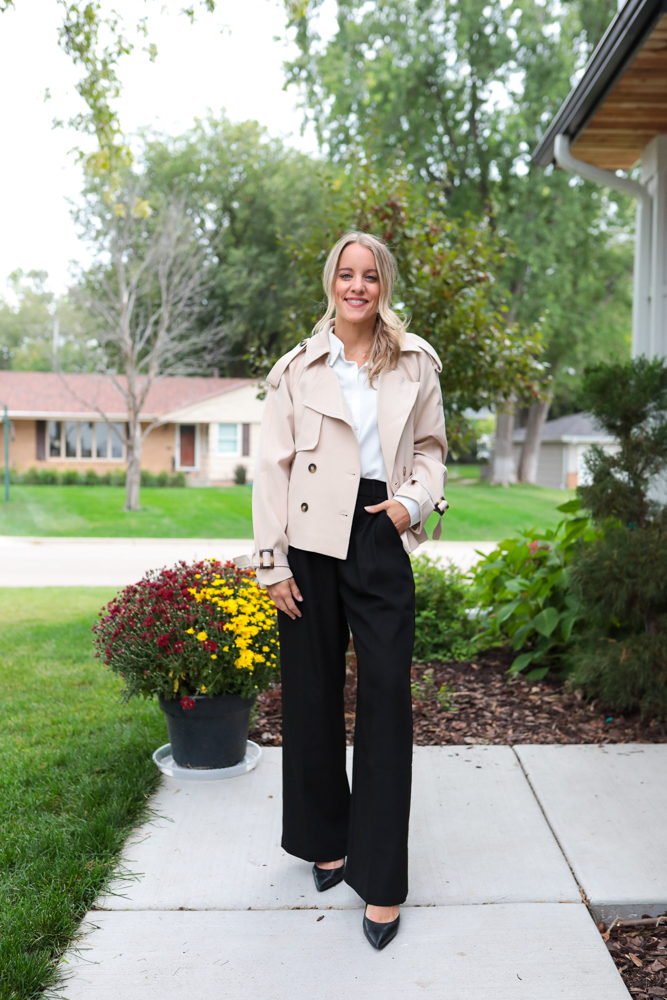 woman in trousers, white tee and cropped trench coat
