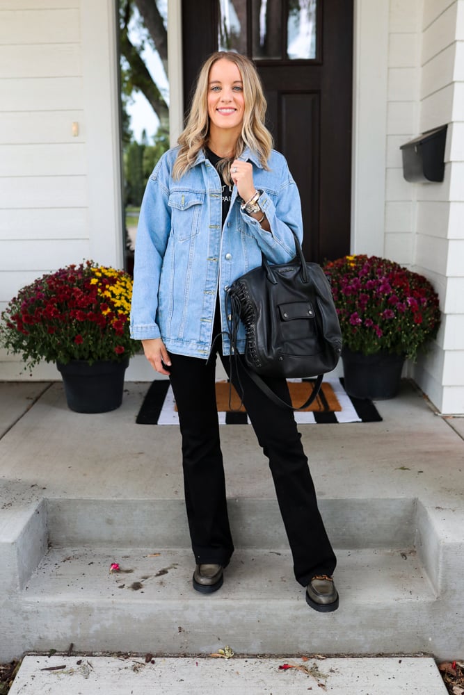 woman wearing black flare jeans, denim jacket and loafers