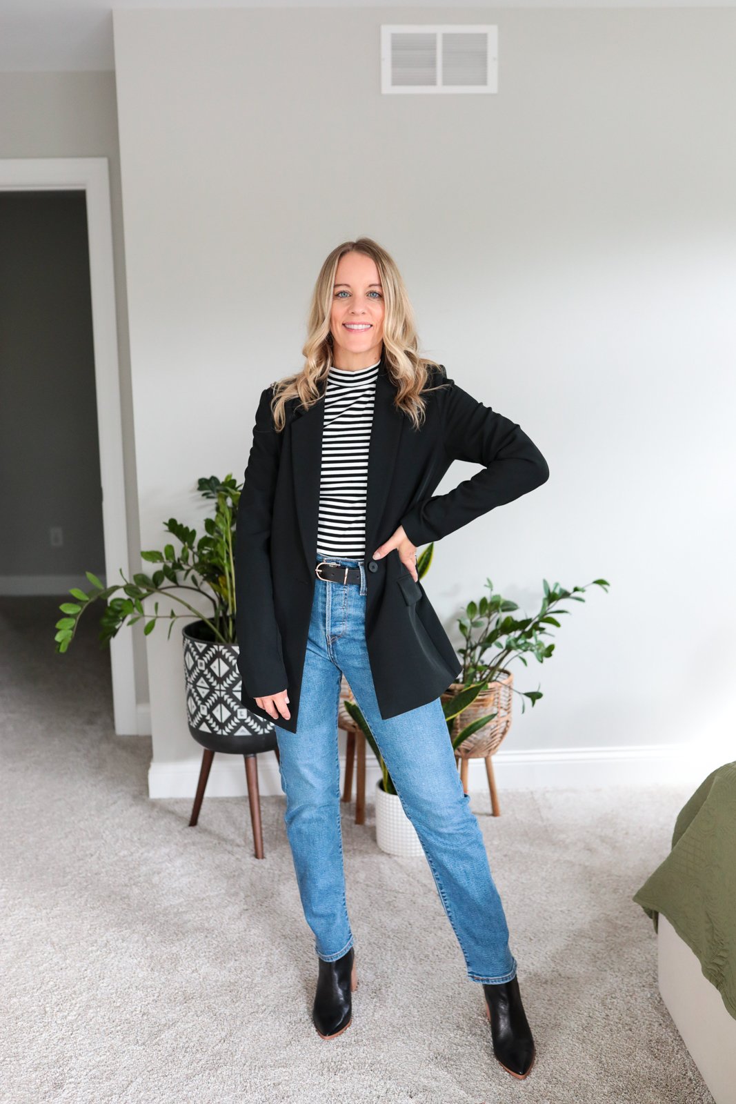 woman wearing black blazer, stripe top and straight leg jeans