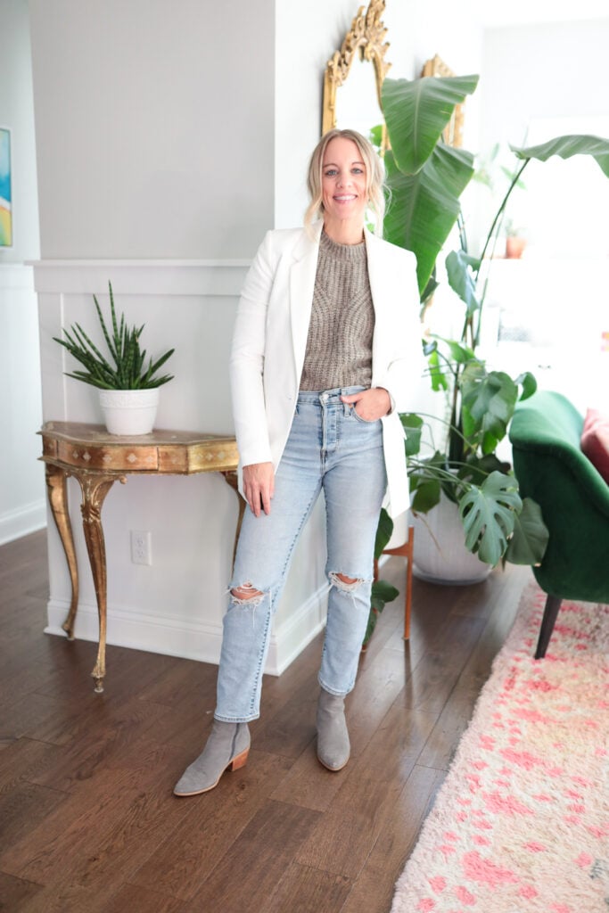 woman wearing a sweater blazer jeans and booties