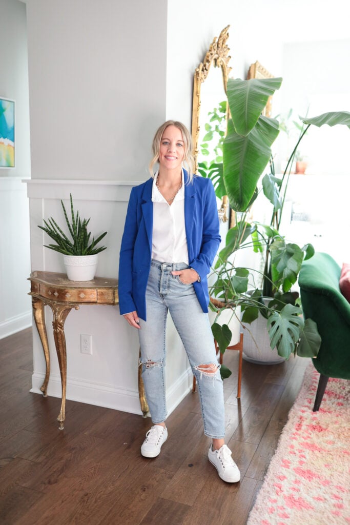 woamn wearing a white button down blue blazer and white sneakers