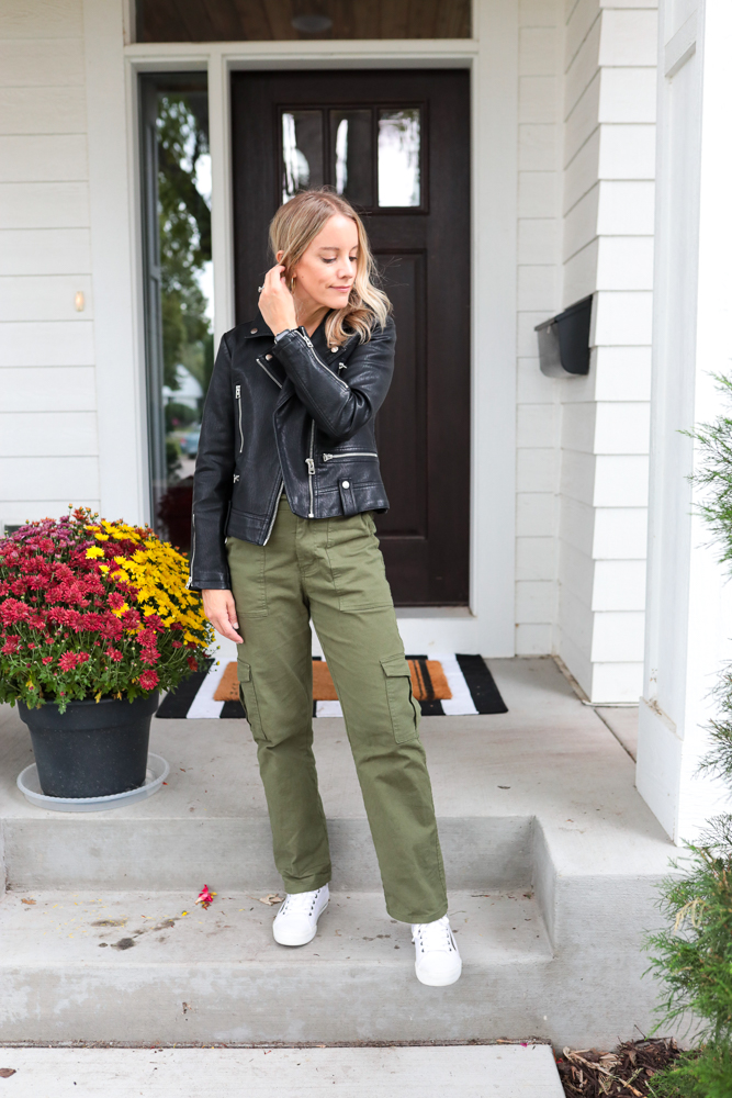 woman wearing green cargo pants, black bomber jacket and white sneakers