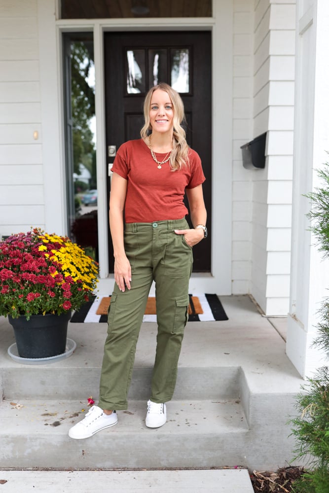 woman wearing green cargo pants, rust t-shirt and white sneakers