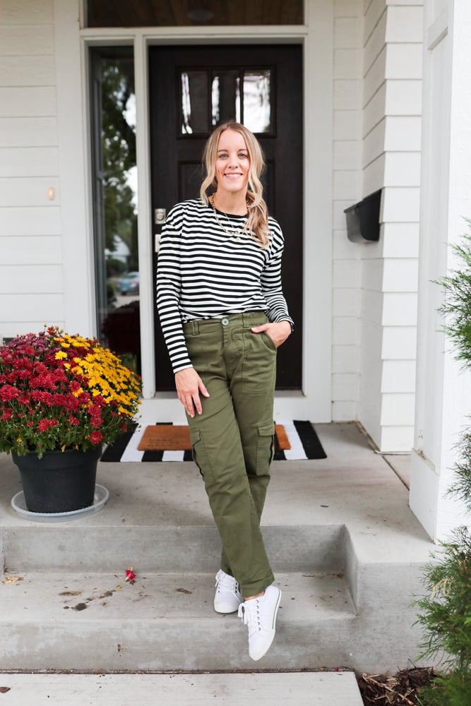 woman wearing green cargo pants, black and white stripe top and white sneakers