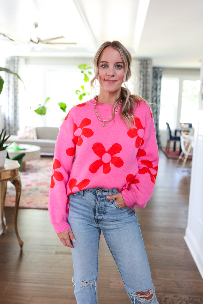woman in hot pink sweater with red flowers on it