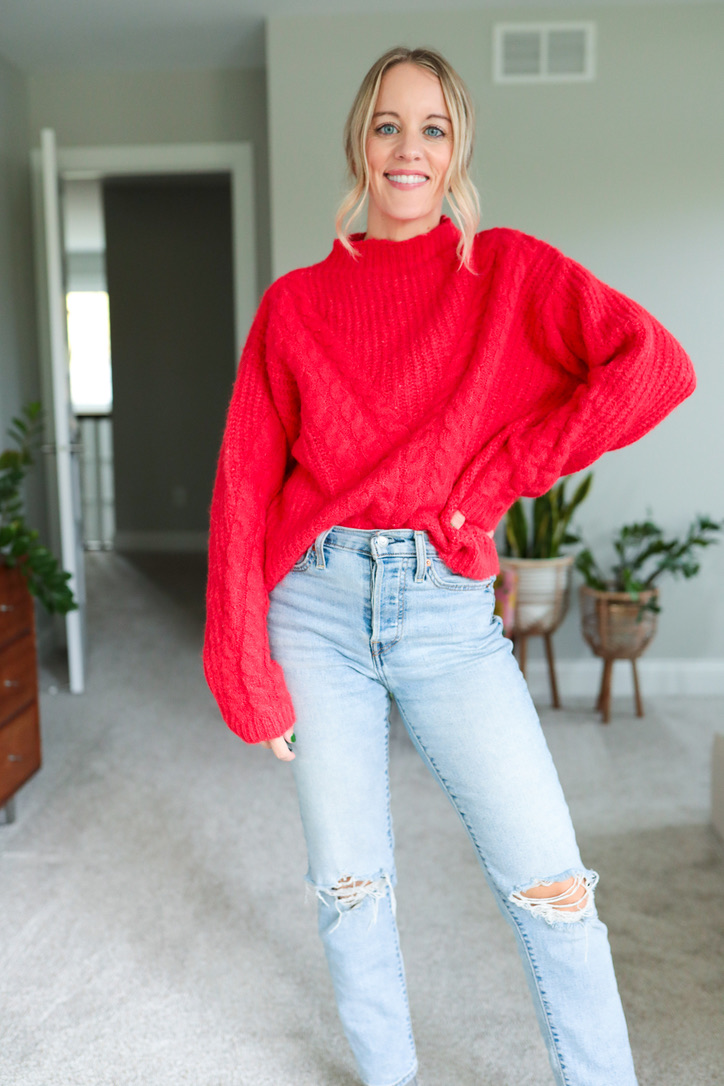 red sweater and distressed jeans