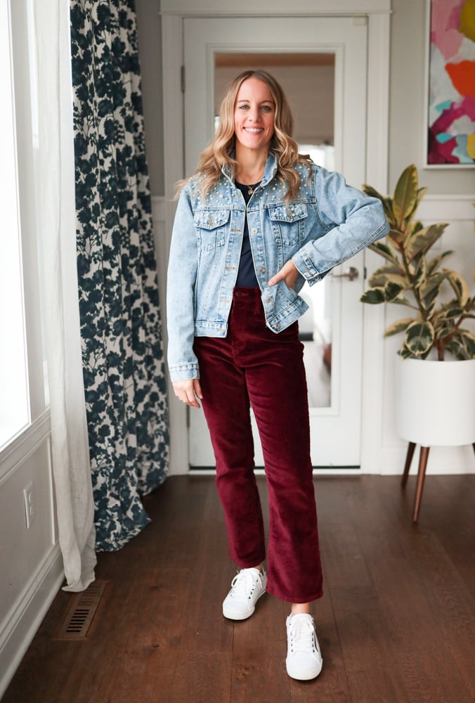 Woman wearing burgundy pants and denim jacket and sneakers
