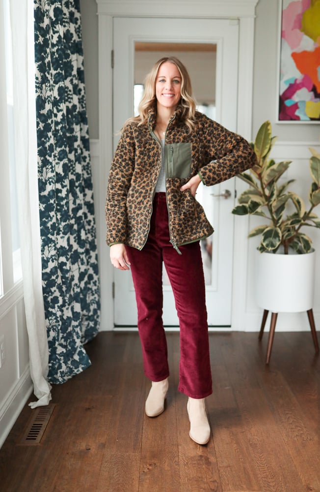 Woman wearing burgundy pants and cheetah print jacket.