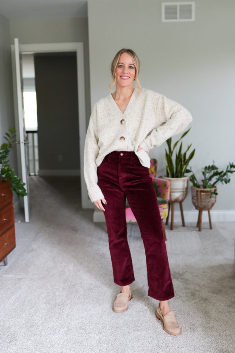 Woman wearing burgundy pants and tan button down cardigan and loafers
