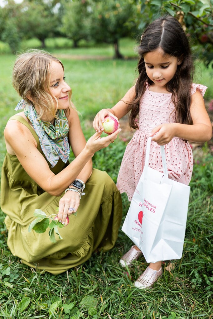 mom handing her daughter an apple