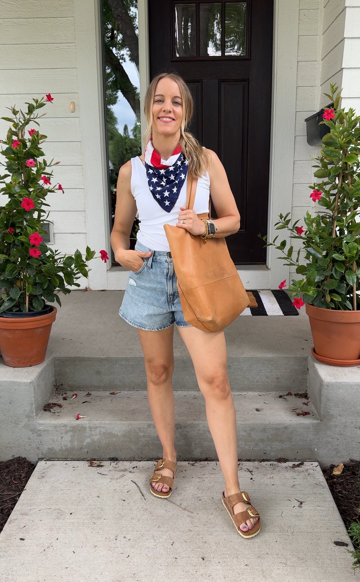 Woman wearing shorts, white tank and american flag bandana.