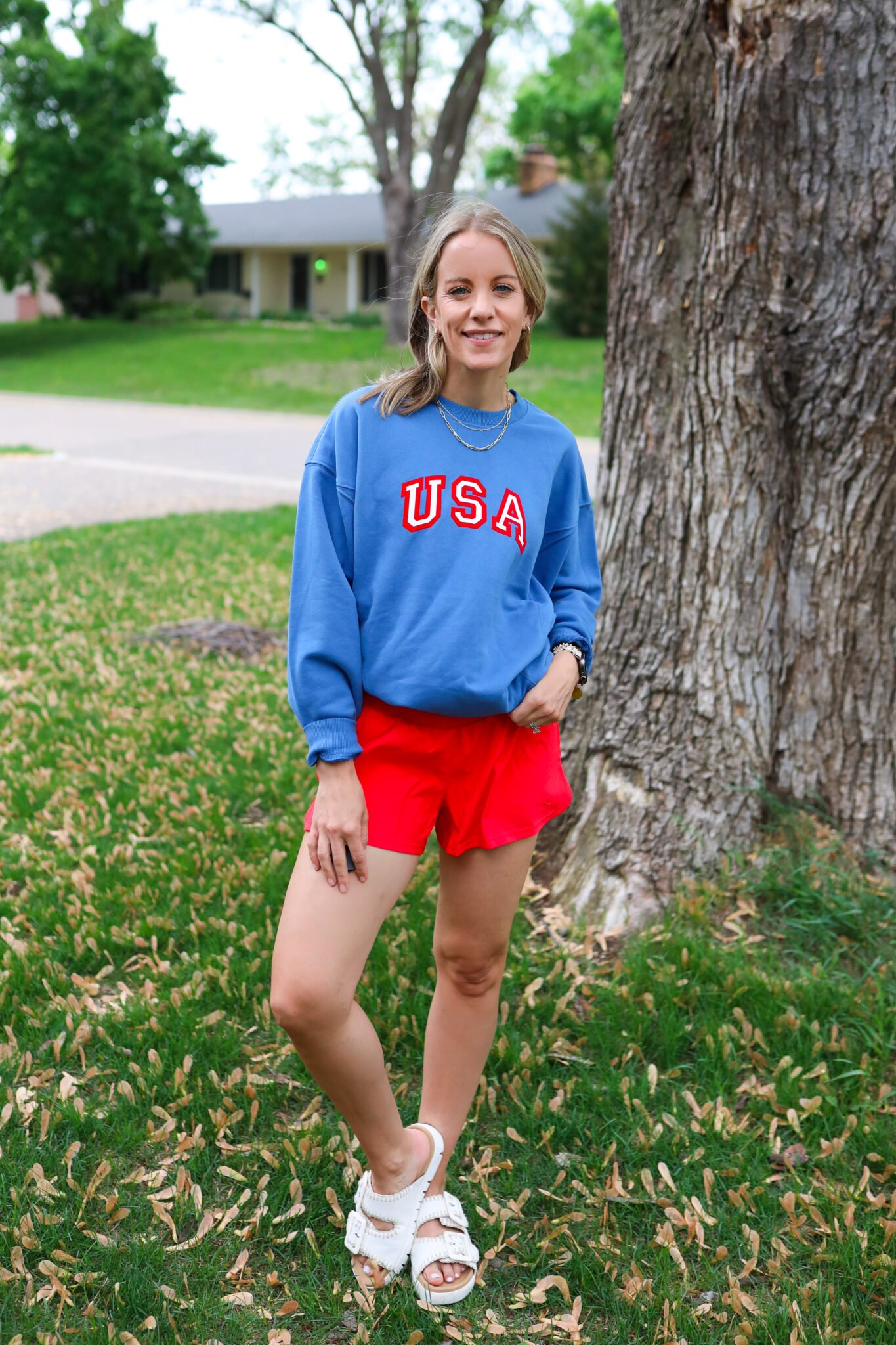 Dark blue USA sweatshirt from Target paired with red shorts and neutral sandals for a bold yet comfy 4th of July look.