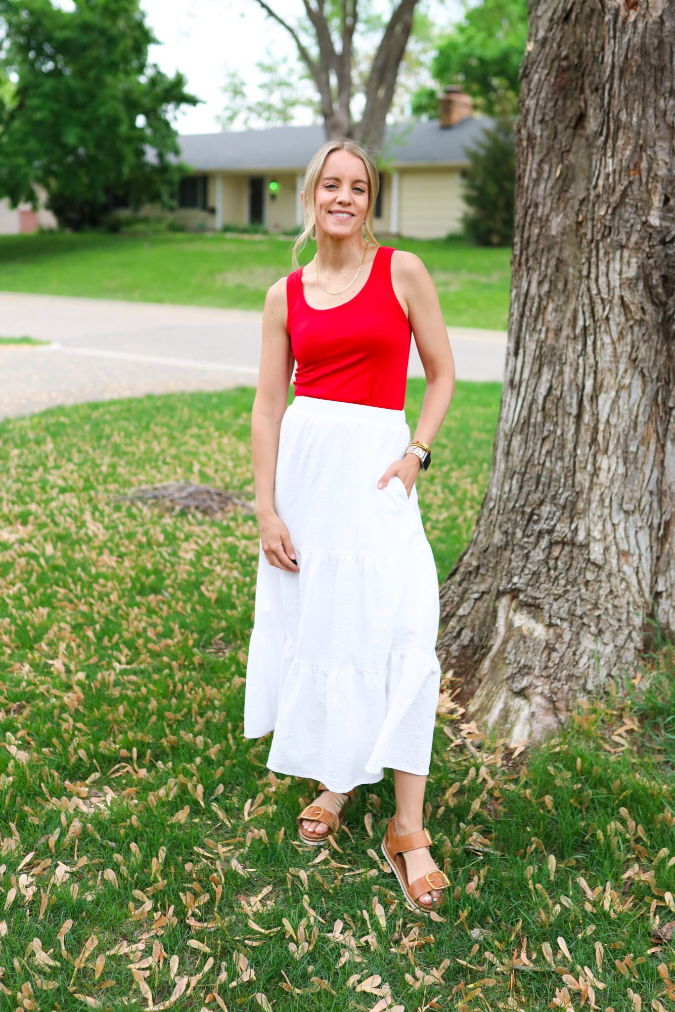 Minimal red tank and flowy white maxi skirt with comfy neutral sandals, styled for a modern and relaxed Independence Day outfit.