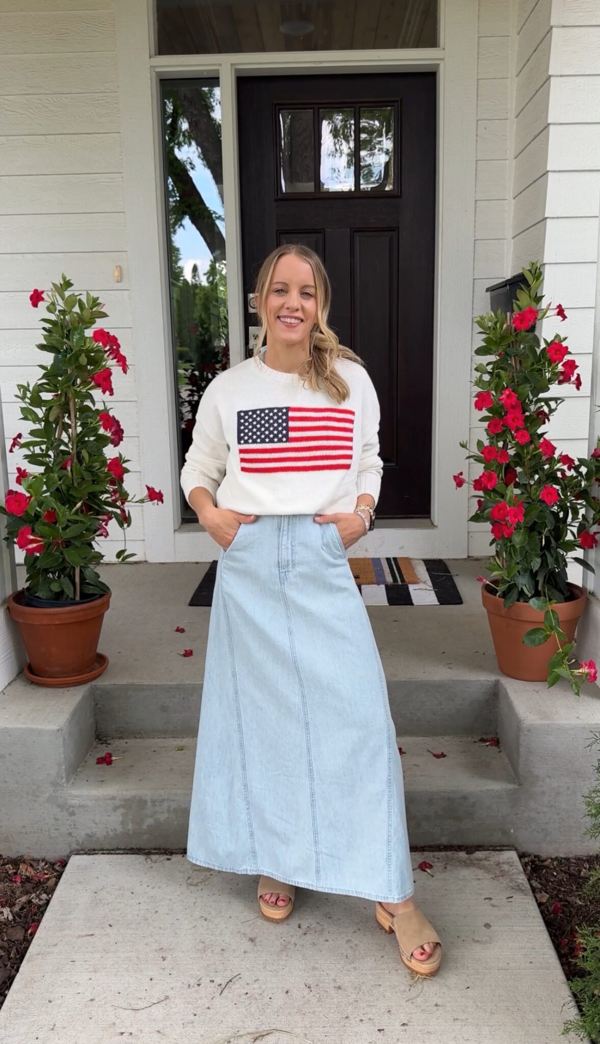 Woman wearing denim dress and American flag sweater.