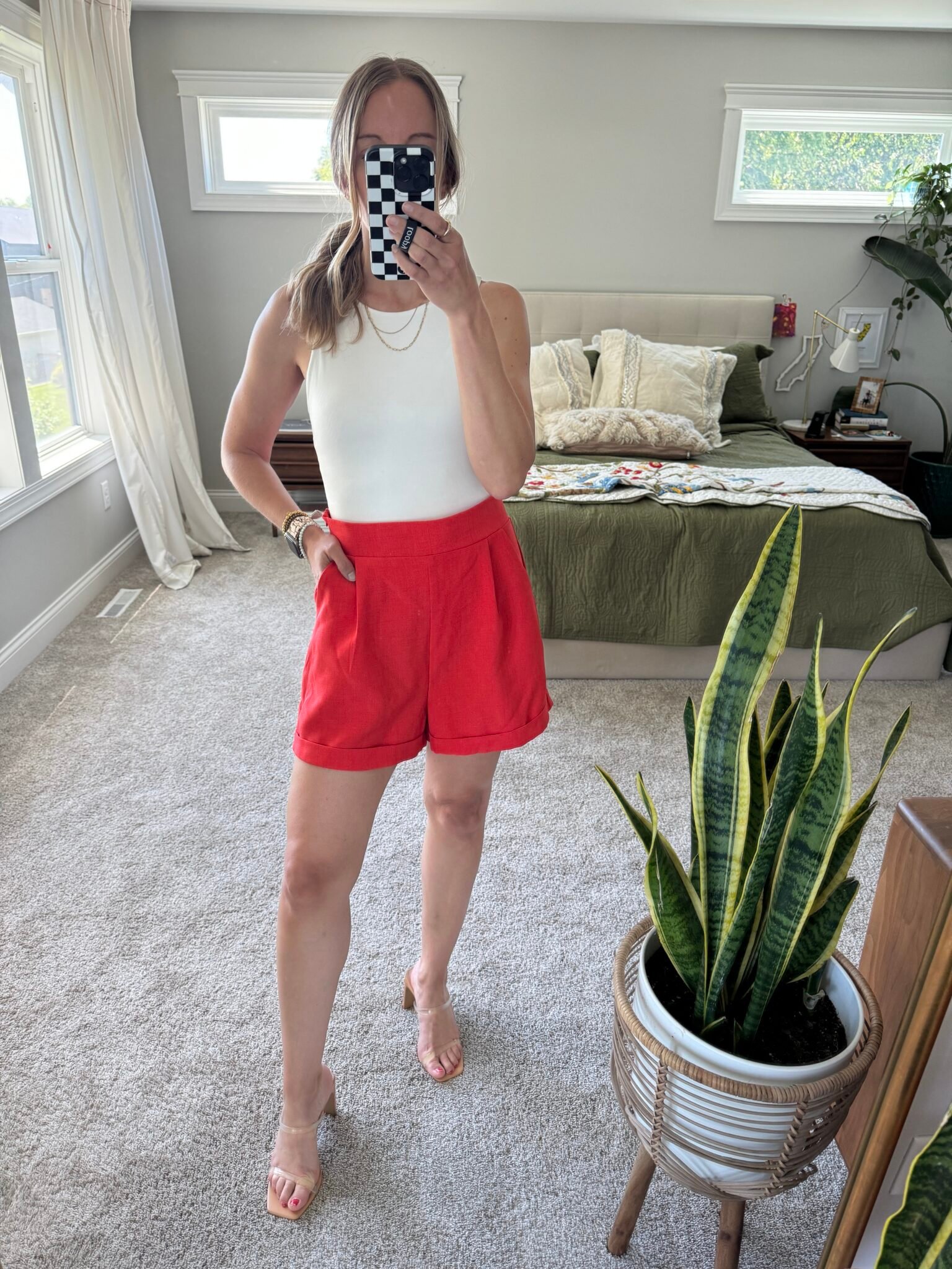 Woman in white tank and red shorts.