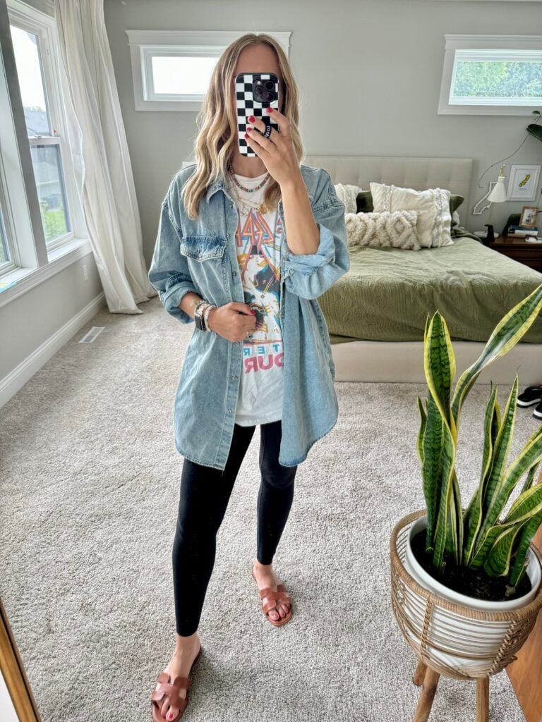 Woman in black leggings, graphic tee and chambray top.