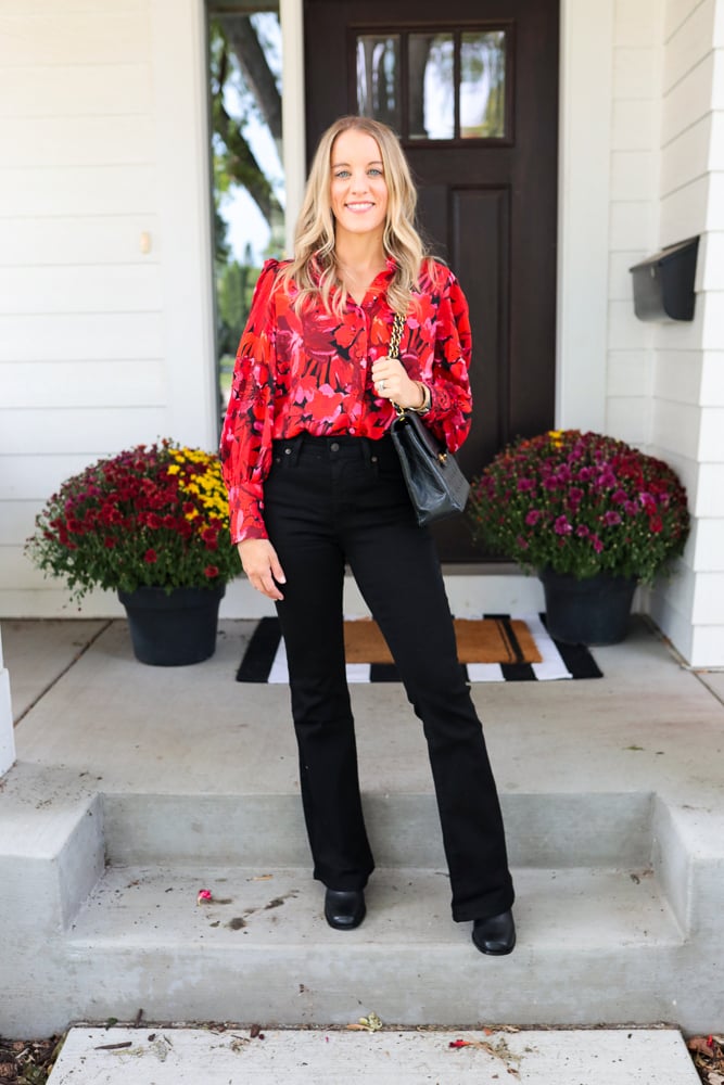 woman wearing floral blouse, black jeans, and boots
