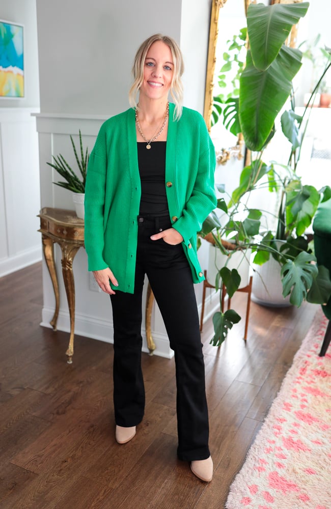 woman wearing black tank top, black jeans, oversized cardigan, and necklace