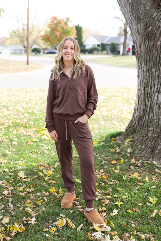 Woman wearing sweater set and slippers.