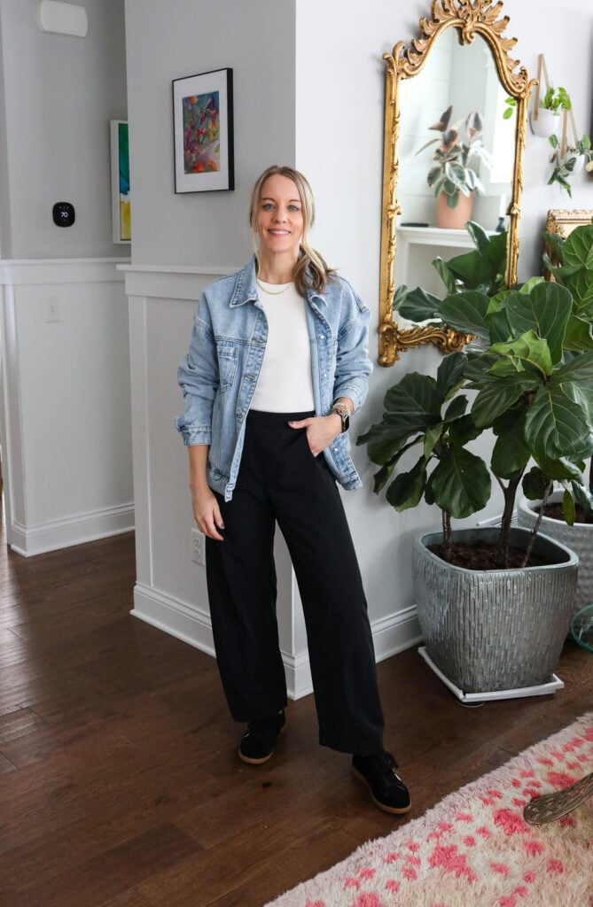 Woman in black joggers, tan top and denim jacket
