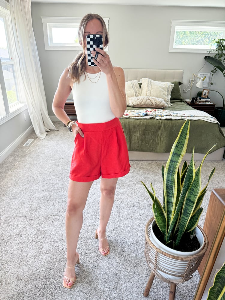 woman wearing resort wear look consisting of a white tank and trouser shorts