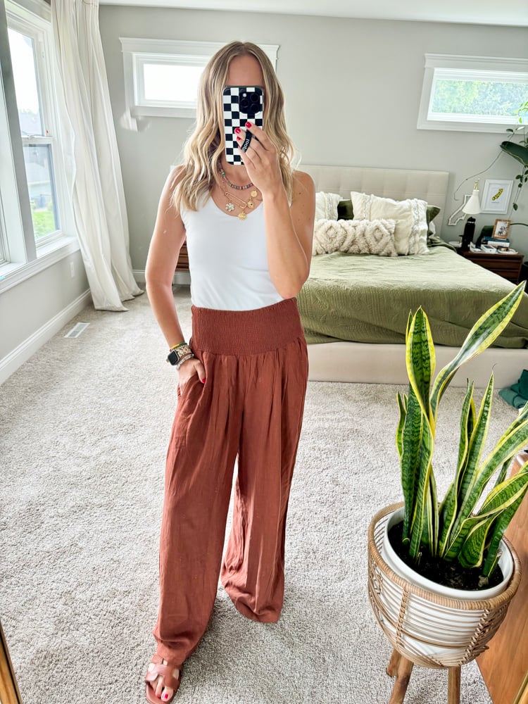 woman wearing a white tank and linen pants 